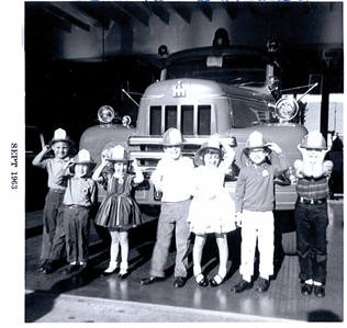 Black and white photo of children on a fire station tour